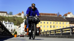 Christian Rottenegger beim Überqueren der Salzach in Burghausen. Im Hintergrund auf dem Berg die längste mittelalterliche Burg Europas.